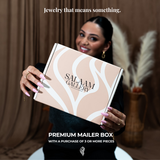 Woman holding a Salaam Gallery premium mailer box with text about jewelry.