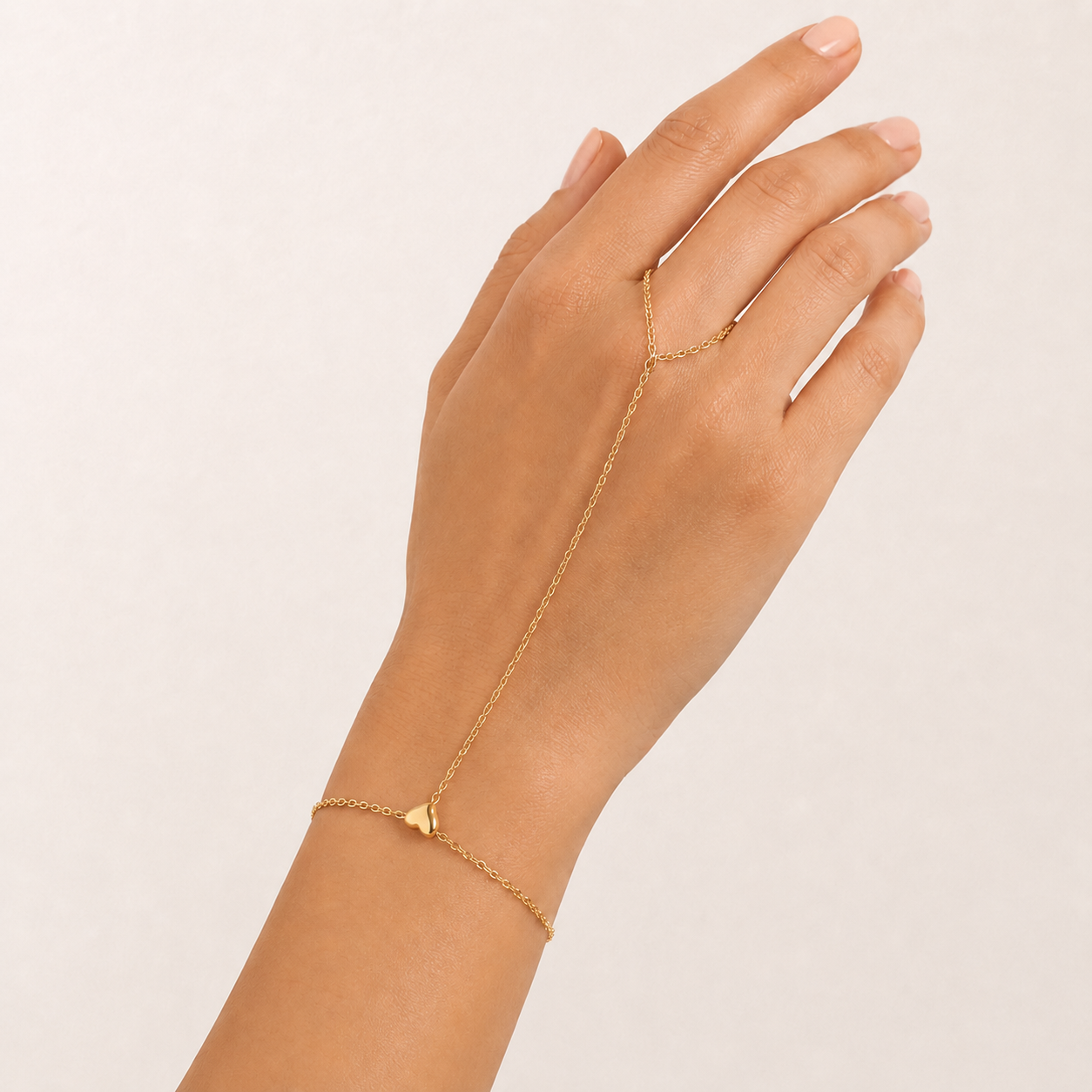 Close-up of the Amira Heart Hand Chain showing the polished heart centerpiece and fine gold chain