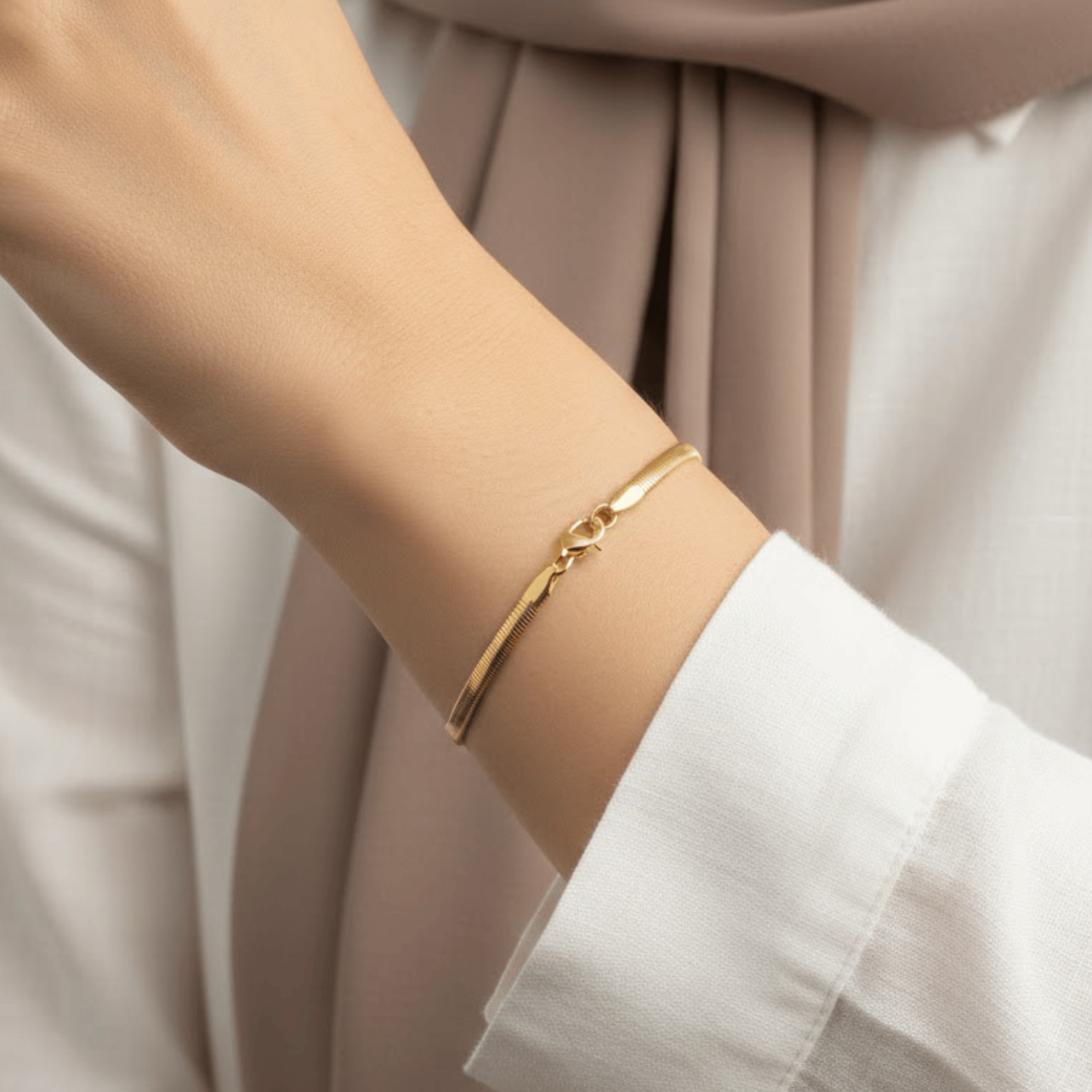 Dainty Herringbone Bracelet worn on wrist featuring sleek flat 18K gold plated stainless steel chain