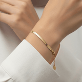 Flat Herringbone Bracelet worn on wrist featuring wide polished 18K gold plated stainless steel chain