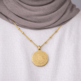 Gold Guide Us to the Straight Path Necklace worn by a modest woman, featuring Quran verse from Surah Al-Fātiḥah, styled over a white top and neutral hijab.