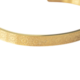 Close-up of gold Hidden Reminder Cuff showing intentionally subtle Arabic engraving of Sabr, Shukr, and Tawakkul.