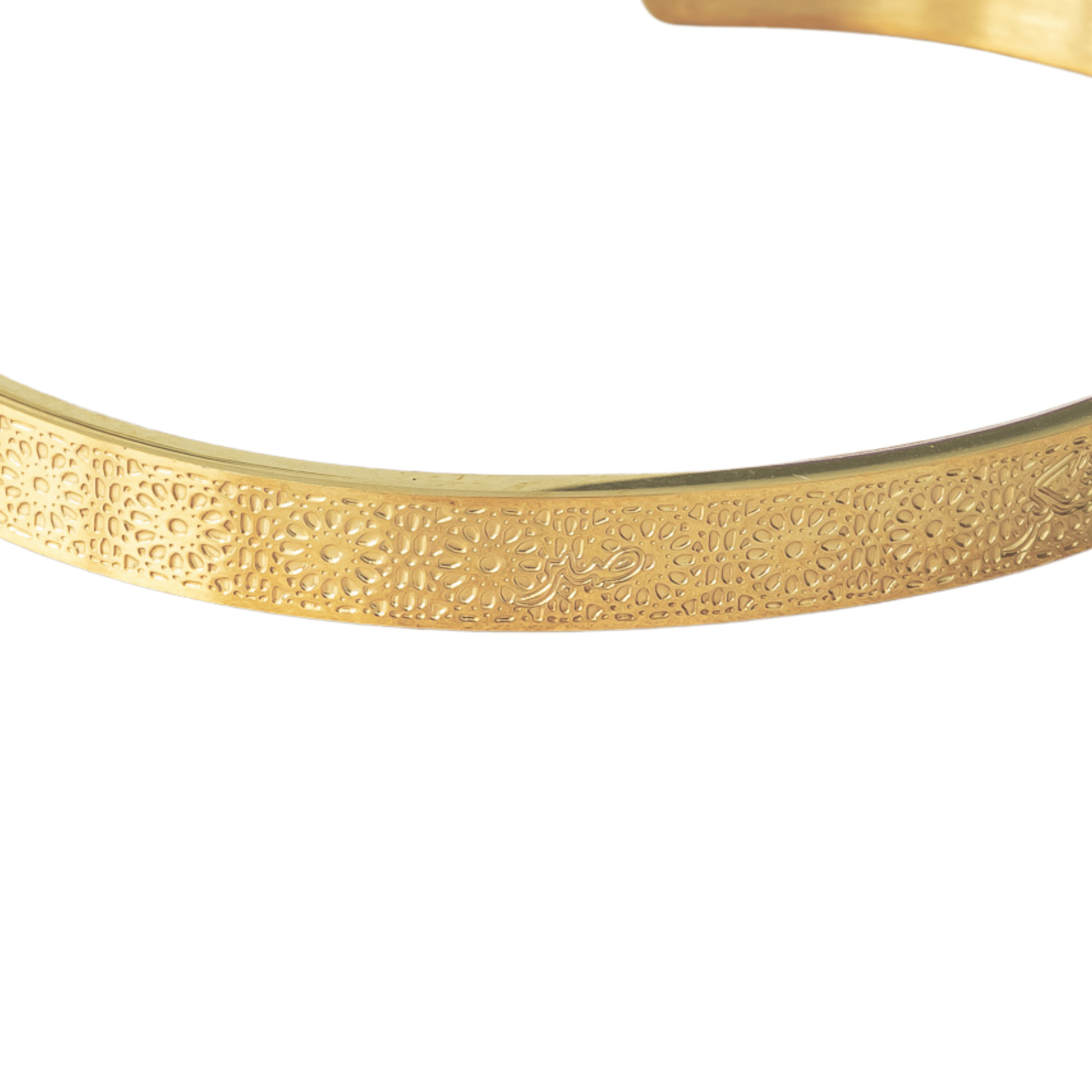 Close-up of gold Hidden Reminder Cuff showing intentionally subtle Arabic engraving of Sabr, Shukr, and Tawakkul.