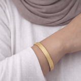 Close-up of gold Hidden Reminder Cuff showing intentionally subtle Arabic engraving of Sabr, Shukr, and Tawakkul.