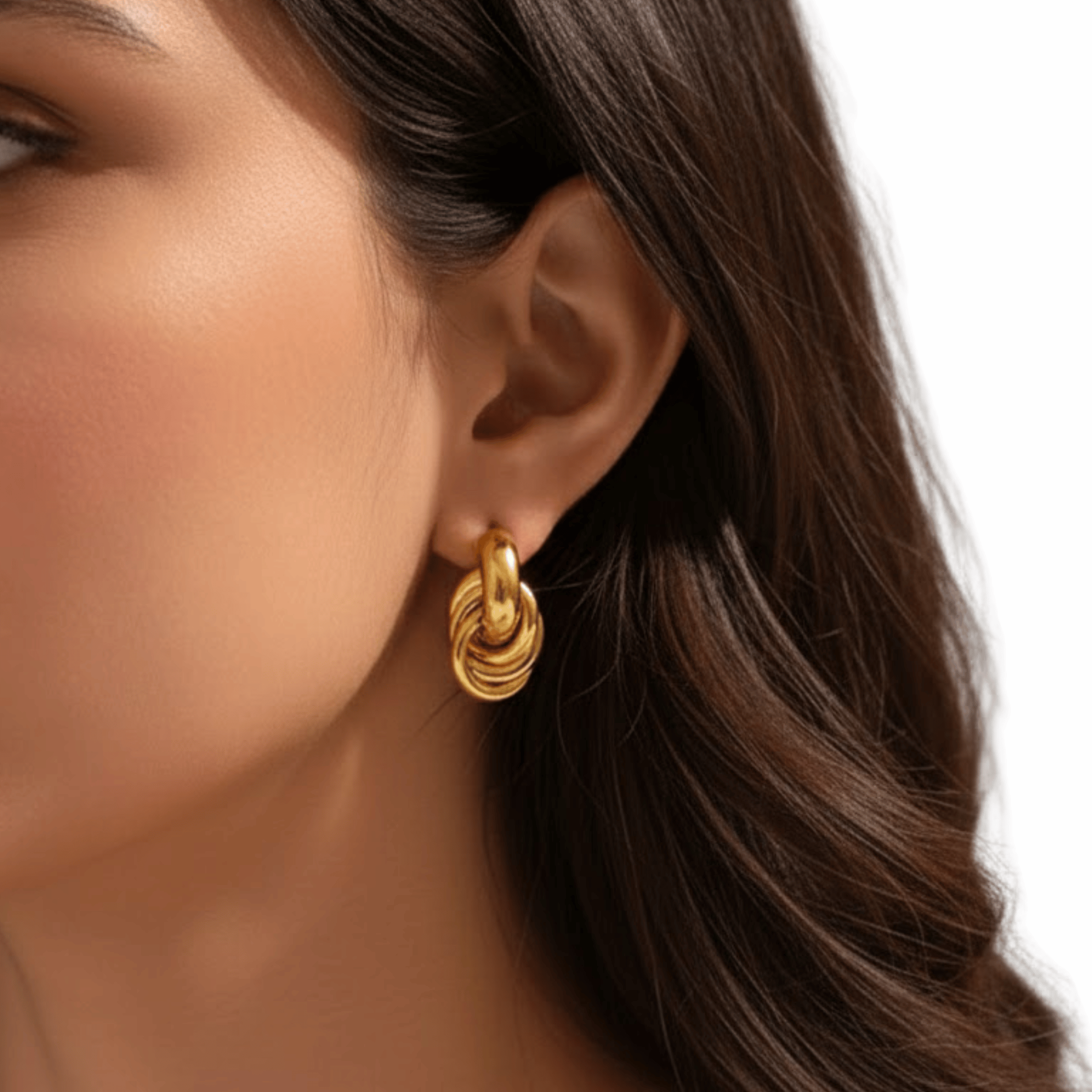 Model wearing Royale Interlock Earrings in 18K gold plated stainless steel with bold interlocking knot design.