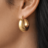 Model wearing Sculpted Gold Hoops in 18K gold plated stainless steel with smooth dome silhouette